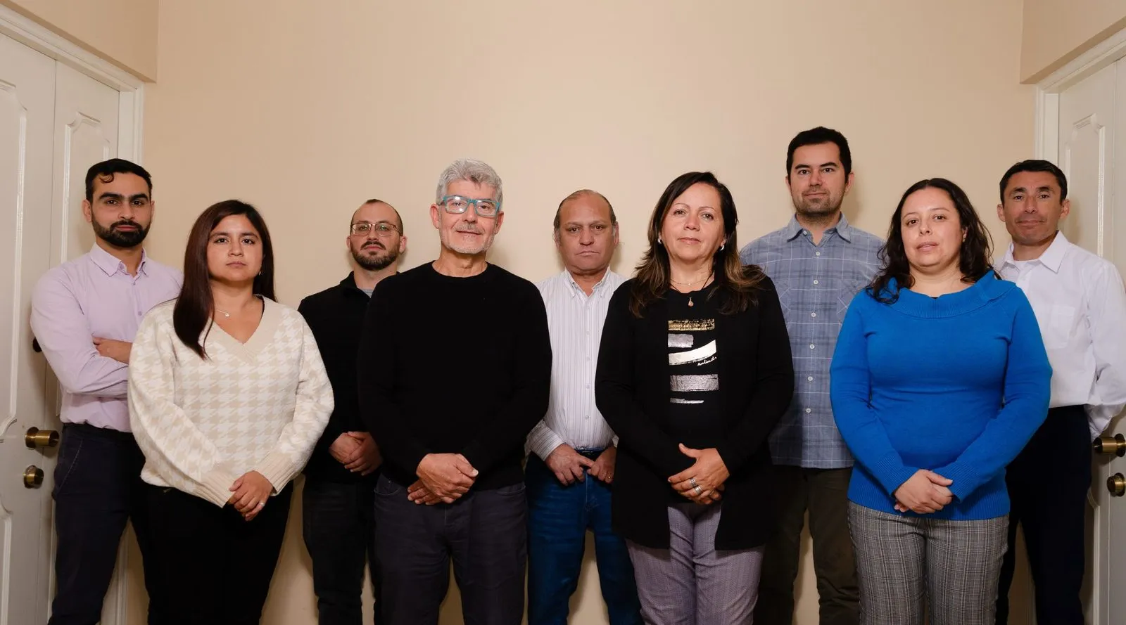 El equipo de EMOJ Consultora: nueve personas de pie, una junto a otra.